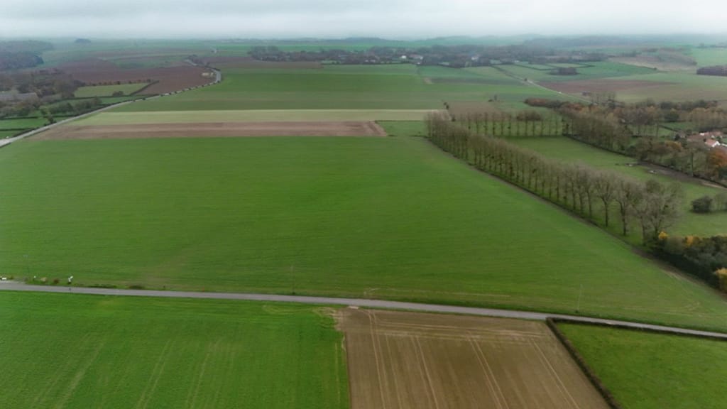 Aerial view south over the battlefield. Tramecourt on the left, Azincourt on the right. Still remnants of the forests that defined the battlefield. The French Army faced this way and most of the fighting was between the Azincourt-Tramecourt Road in the foreground and that lighter coloured field halfway along