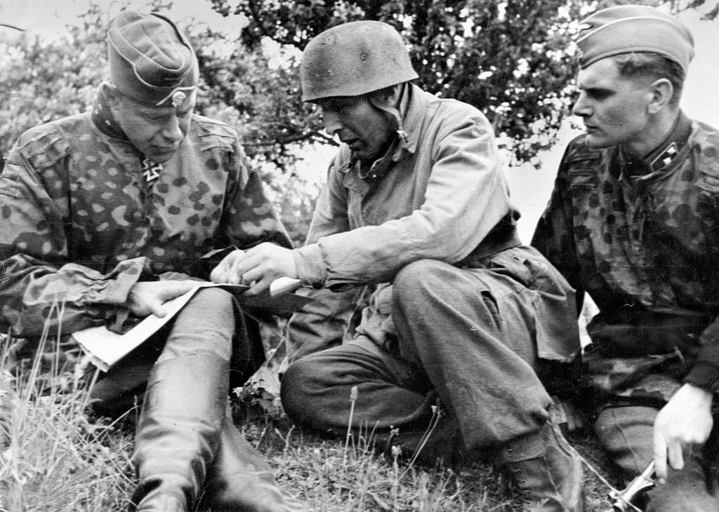 Bloody Gulch. SS-Brigadeführer und Generalmajor der Waffen-SS Werner von Ostendorf (left), commander of the 17. SS-Panzergrenadier-Division ‘Götz von Berlichingen' plans the counterattack on Carentan with commander of the Fallschirmjäger-Regiment 6, Major Friedrich August Freiherr von der Heydte (centre)