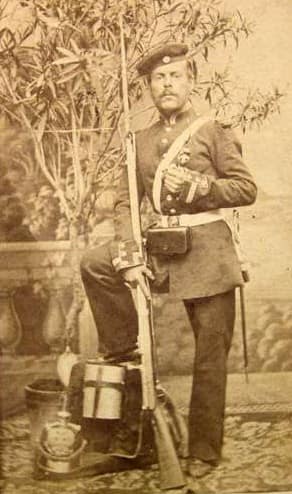 Prussian infantryman 1870-71. Equipped with a Model 1862 Dreyse Needle-Rifle. He wears a Kratzchen cap, and his Model 1860 pickelhaube is on the ground beside him.