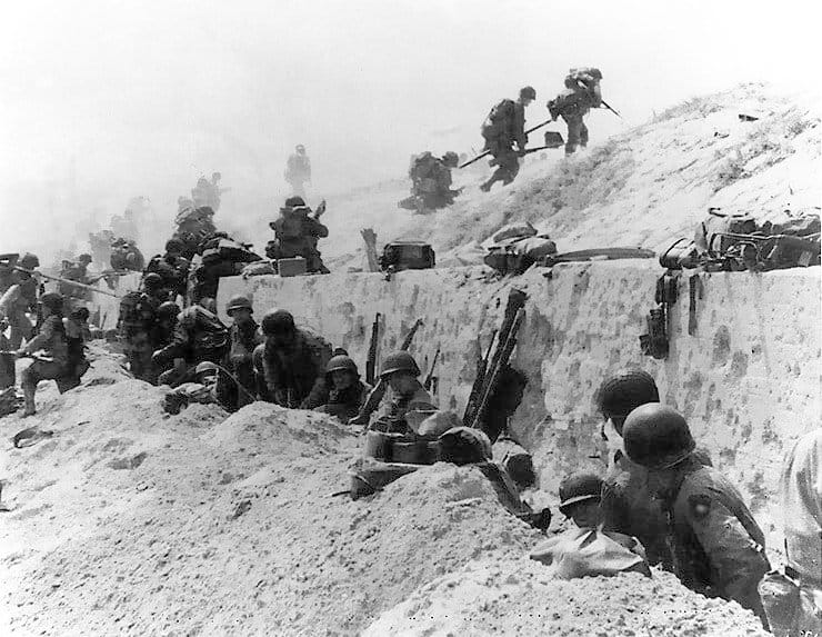 Troops of the US 4th Division move out over the seawall on Utah Beach