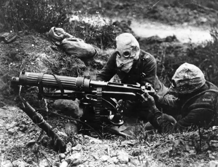 World War One. British machine gun team manning their Vickers water-cooled machine gun, and wearing PH-type anti-gas helmets near Ovillers, July 1916